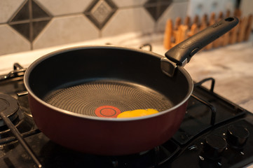Little girl cooks fried eggs in a pan