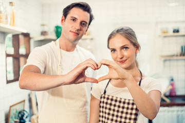 Obraz premium Hand of Caucasian love couple making heart shape together, man and woman standing with smile on face in the kitchen at home, just married people lifestyle prepare for cooking breakfast of lunch