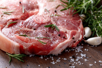 Raw pork with rosemary , salt and pepper.