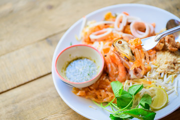 Mussels and stir-fried rice noodles (Pad Thai) on fork.