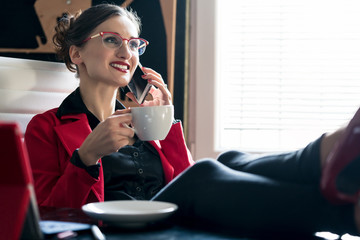 Businesswoman having a coffee using the phone