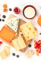 Cheese platter, a flat lay top shot on a white background. Blue cheese, Dutch cheese, and others, a variety with fruits and nuts