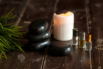 Fototapeta na wymiar Massage stones and candle close-up on a wooden dark background