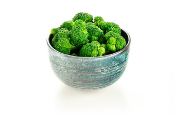 A bowl of cooked broccoli on a white background