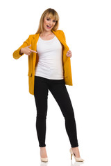 Woman In Yellow Jacket Is Pointig At Herself And Talking