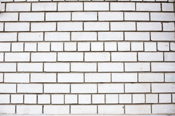 Old white brickwall textured background. Dirty and grungy texture of brick masonry. Outdoor urban surface. Façade of a building. Bricks with cement (concrete) in grunge solid laying. Stonework pattern