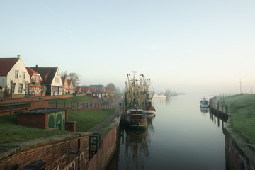 Fototapeta premium Fischerhafen in Greetsiel im Nebel