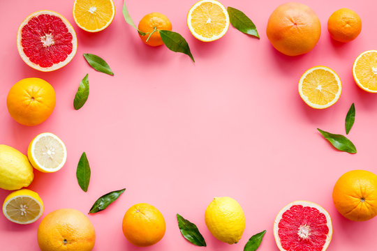 Citrus fruits - lemons, grapefruits - on pink background mockup, frame top-down copy space