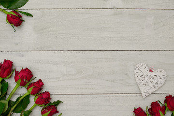 Romantic background, white wooden planks with natural red roses and white heart for concepts, posters or design.