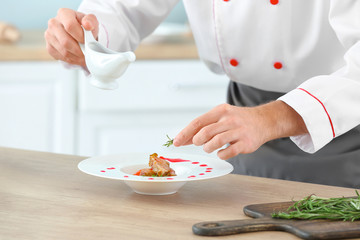 Obraz na płótnie Canvas Male chef cooking in kitchen, closeup
