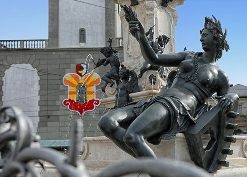 Der Augustusbrunnen, einer der Prachtbrunnen in Augsburg mit der Statue der Singold un im Hintergrund der Perlachturmgeschm&uuml;ckt f&uuml;r das Turamichele Fest