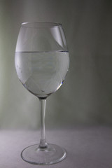 Glass of water on a white background with side lighting.