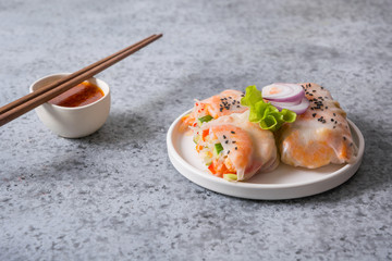 Vietnamese food spring rolls with shrimps, noodles, vegetables on grey background. Close up. Asian cuisine.