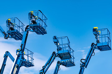 Articulated boom lift. Aerial platform lift. Telescopic boom lift against blue sky. Mobile...