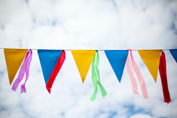 multi-colored flags on a rope against the sky