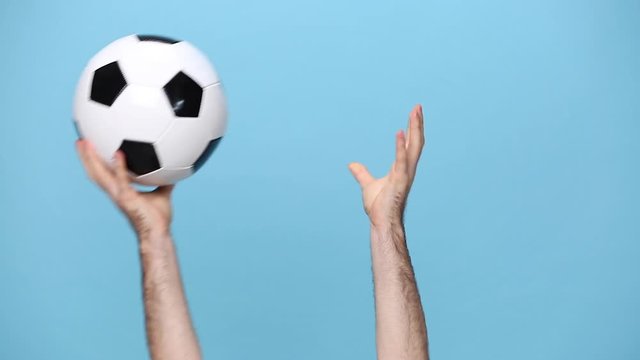 Close up cropped man football fan cheer up support favorite team with soccer ball, hands arms throw ball isolated on pastel blue background studio. People sport family leisure lifestyle concept.