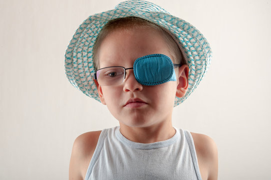 Child in glases with Occluder. Ortopad Boys Eye Patces nozzle for glasses for treating strabismus (lazy eye)