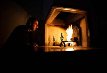 Man relaxing sitting close to a blazing fire