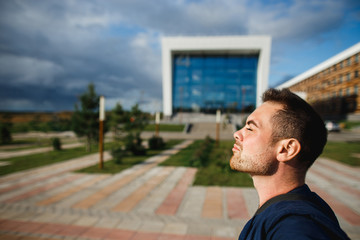 Handsome male student near university sunny day.