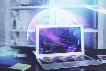 Computer on desktop in office with technology theme hologram. Multi exposure. Tech concept.
