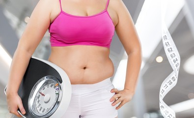 Fat female belly and scale and measuring tape