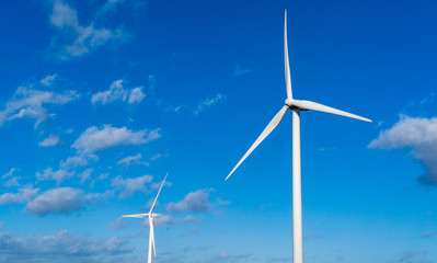 Two wind turbines set against a blue sky