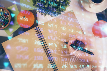 Forex chart hologram on hand taking notes background. Concept of analysis. Double exposure