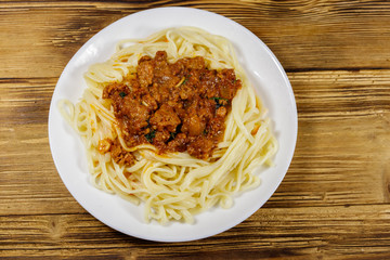 Pasta with bolognese sauce on wooden table