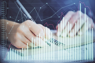 Forex graph on hand taking notes background. Concept of research. Double exposure