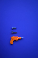 orange drill on a blue background and two gray bolts