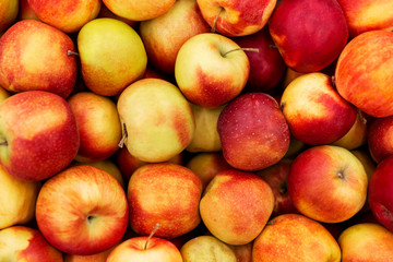 Many juicy bright apples on the market. View from above. Close-up. Background.