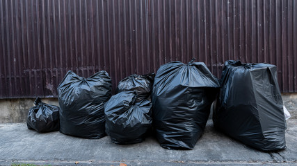 Many black bags, garbage bags beside the leaky walls