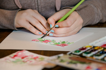 Kind malt schönes Aquarell mit Pinsel, Blumenmotiv, Blüten, Blumen