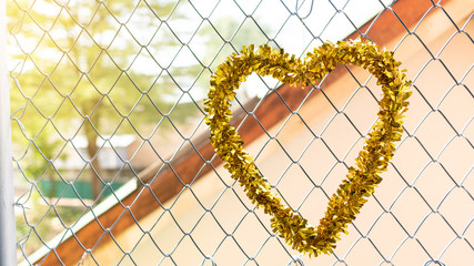 The golden heart-shaped garland hung at the windows on the metal mesh.