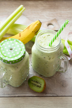 green smoothies with fresh fruits and vegetables, measuring tape, vertical image