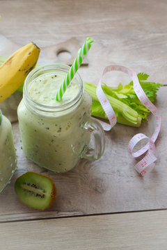 fresh smoothies with green fruits and vegetables, measuring tape, vertical image