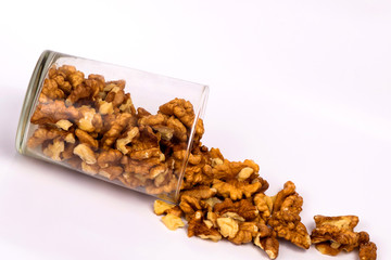 Walnuts in a glass. Scattered peeled nuts. Glass jar with peeled walnuts.