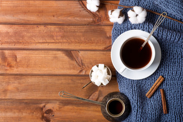 cup with coffee on a wooden table, cotton flower, homeliness, knitted plaid