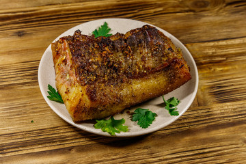 Baked pork belly in a plate on wooden table