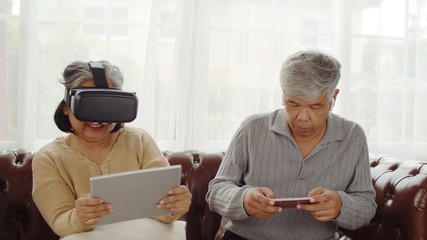 Senior woman having fun to playing game in VR glasses