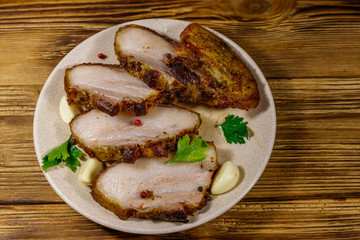 Baked pork belly in a plate on wooden table