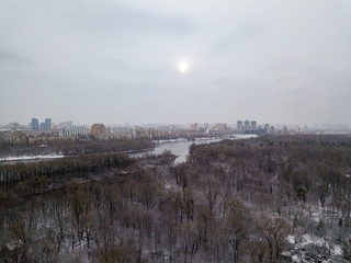 Aerial drone view. Snowy forest on a cloudy morning.