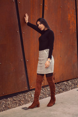 Beautiful girl model posing against the background of the modern building