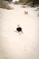 Children climbing sand dunes at Portland beach in Victoria, Australia