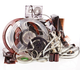 Vintage film camera rolls, old audio and video casettes with tape and foto strip isolated on a...