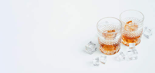 two glasses of whiskey with ice on a white background with place for text