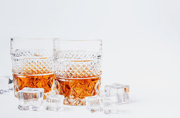 two glasses of whiskey with ice on a white background with place for text