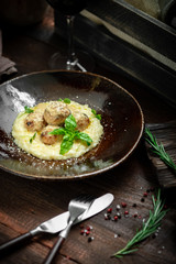 Beef meatballs with risotto in cream sauce in a plate on a wooden background. Italian cuisine rustic style