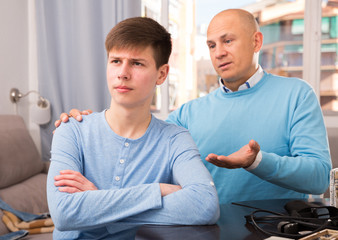 Obraz premium Father calming upset teenage son