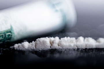 white powder (heroin, cocaine, narcotic) scattered in the form of a track, a bill folded into a...